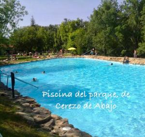 una gran piscina con gente. en Las Casitas de Cerezo 3, en Cerezo de Abajo