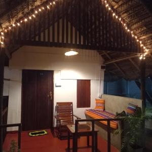 a room with chairs and a table and a bed at Bamboo Bay in Arugam Bay +86 photos