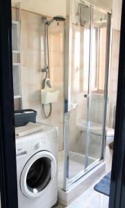 uma máquina de lavar roupa na casa de banho com um chuveiro em Casa Serendipity Sabaudia em Sabaudia