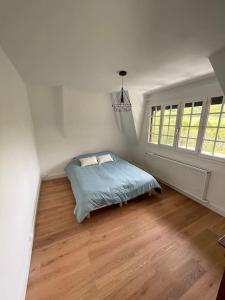 ein Schlafzimmer mit einem Bett in der Ecke eines Zimmers in der Unterkunft La Chaumine, cottage in Normandy in Saint-Germain-de-Pasquier