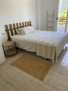 ein Schlafzimmer mit einem großen Bett und einem Stuhl in der Unterkunft Apartamento en Voramar a 2 minutos de la playa in Benicàssim