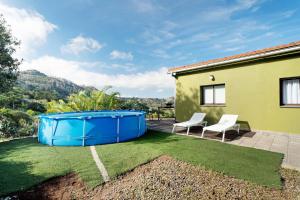 einen Hinterhof mit einem Whirlpool und 2 Stühlen in der Unterkunft Comfort apartment Casa Lomo El Aire Acevino with outdoor pool in Tegueste