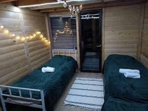 Zimmer mit 2 Betten und einem Kronleuchter in der Unterkunft Avlija Biberović in Sjenica