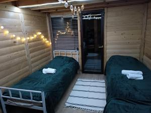 a room with two beds and a chandelier at Avlija Biberović in Sjenica