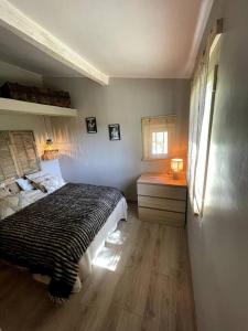 a bedroom with a bed and a desk and a window at La maison d'Eddy et Caro aux Portes du Verdon in Trigance