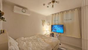 a bedroom with a bed and a tv on the wall at Evermore #Sinchon station 5min #Seogang station 1min in Seoul