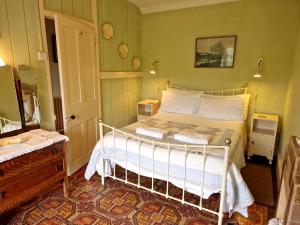 a bedroom with a white bed in a room at Brynifor Llangrannog in Llwyn-Dafydd