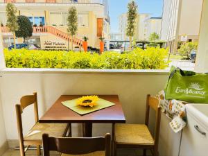 une table avec une fleur jaune sur une serviette dans l'établissement Condominio GIULIANA, à Bibione