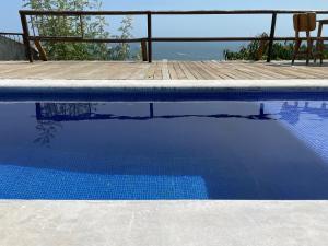 einen blauen Pool mit Holzterrasse in der Unterkunft Loft Horizonte Arte 2 in Puerto Escondido