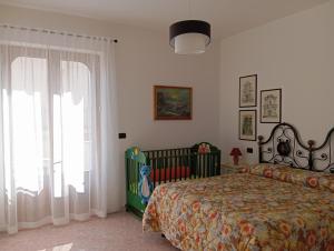 カストロ・ディ・レッチェにあるScorcio di mareのベッドルーム1室(ベッド1台、ベビーベッド1台付)