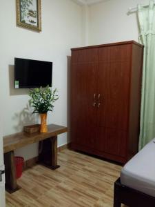 a living room with a tv and a wooden cabinet at Anh Đào Dalat House in Da Lat +9 photos