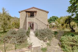 an external view of a stone house with a garden at Agriturismo Il Mulino delle canutole in Magione
