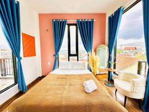 大叻的住宿－Be Youth Villa Đà Lạt，一间卧室配有一张带蓝色窗帘的大床