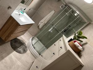 a bathroom with a glass shower and a sink at Near Sandefjord AirPort and walking distance to City center in Sandefjord