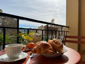 a table with a plate of pastries and a cup of coffee at Résidence Libertà - T4 spacieux, calme, lumineux, centre ville, loggia et balcon in Calvi