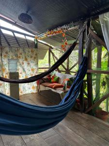 a blue hammock in a room with a bed at Refugio Maiku Puerto Nariño in Puerto Nariño