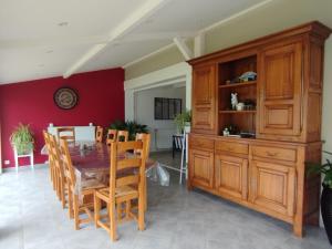 a dining room with a table and wooden cabinets at Le champ Vert in Chamblanc