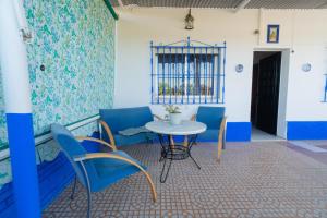Habitación con mesa, sillas y ventana en Vivienda Unifamiliar 500 m cuadrados en Isla Cristina