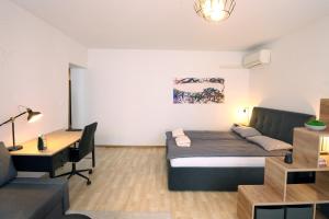 a bedroom with a bed and a desk in a room at City Center Modern Suite JAKAM in Koper