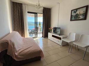 a bedroom with a bed and a television and a balcony at Villa Bellevue in Neum