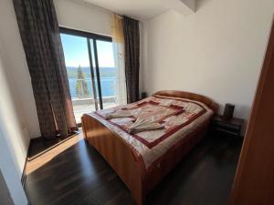 a bedroom with a bed and a large window at Villa Bellevue in Neum