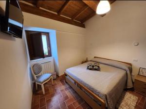 a bedroom with a bed and a television and a chair at B&B Tussillo in Tussillo