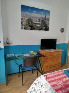 - une chambre avec un bureau, un ordinateur et un lit dans l'établissement Chambre avec vue sur jardin et salle de bain à partager, à Cluses