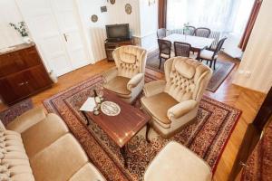 sala de estar con sofá, sillas y mesa en Haus in Budapest mit großem Garten für Familien und Hund en Budapest