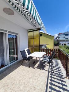 a patio with a table and chairs on a balcony at Apartment Marija Selce in Selce