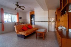 uma sala de estar com um sofá laranja e uma mesa em Vivienda Unifamiliar 500 m cuadrados na Isla Cristina