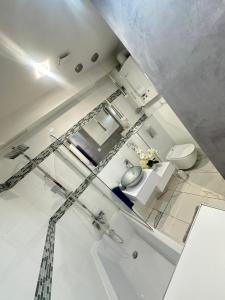 uma casa de banho branca com um lavatório e um WC em Apartament w centrum em Świebodzin