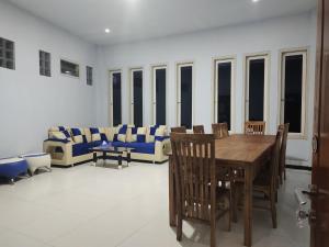 - un salon avec une table, des chaises et un canapé dans l'établissement Harmony Resto&Homestay, à Lambangkuning