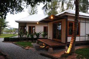 a small house with a bench in front of it at The Farmhouse at Polo Escape in Ban Pong