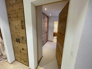 einen Flur mit Holztüren in einem Haus in der Unterkunft Elegant apartment in Flims close to Lake Caumasee in Flims
