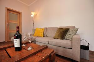 un salon avec un canapé et une bouteille de vin dans l'établissement Słoneczny Apartament przy Rynku, à Wrocław 6 autres photos