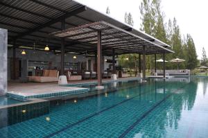 a swimming pool with a pavilion and a swimming pool at The Farmhouse at Polo Escape in Ban Pong
