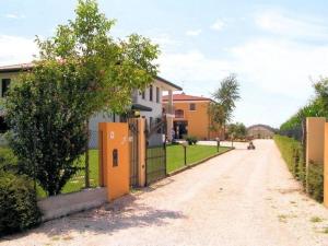 a house with a fence on a dirt road at Schöne Wohnung in Venedig mit Garten und Grill - b57251 in Tessera