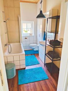 Habach的住宿－Das Fichtlgut Koppl，浴室设有蓝色地毯、浴缸和卫生间。