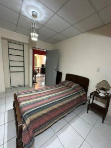 a bedroom with a large bed and a table at El jardín de Sarobe, Depto completo con estacionamiento in Paraná