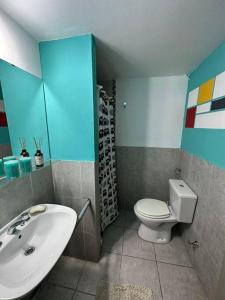 a bathroom with a white toilet and a sink at El jardín de Sarobe, Depto completo con estacionamiento in Paraná