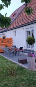 a house with a patio with a table and benches at Haus MaRi in Niederwiesa