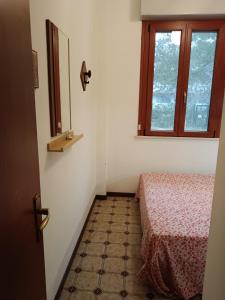 a small room with a bed and a window at Condominio Carina in Bibione