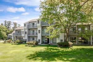 a large apartment building with a large yard at Cozy Beach Front Condo AC Beach Waterfront in Traverse City