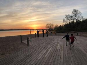 a group of people walking on the beach at sunset at Cozy Beach Front Condo AC Beach Waterfront in Traverse City