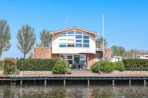 a house on the side of a body of water at Watervilla Workum in Workum