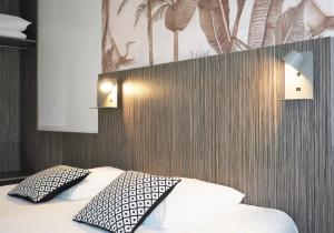 翁德雷的住宿－The Originals City, Hôtel Le Lodge, Bayonne Nord，一间卧室配有一张带两个枕头的床