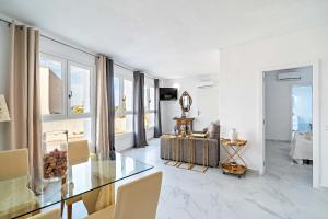 a living room with a glass table and a couch at Apartamentos Dulcemar Frente al Mar con zona SPA in San José +37 photos