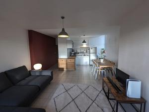 ein Wohnzimmer mit einem Sofa und einem Tisch sowie eine Küche in der Unterkunft Mirador T2 ensoleillé place des Terreaux vue Fourvière in Lyon