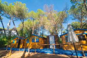 ein Holzhaus im Wald mit Sonnenschirm in der Unterkunft ZALUAY - Habitaciones de madera in Isla Cristina