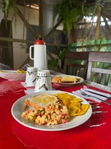 einem Tisch mit einem Teller Essen auf einem roten Tischtuch in der Unterkunft Refugio Maiku Puerto Nariño in Puerto Nariño